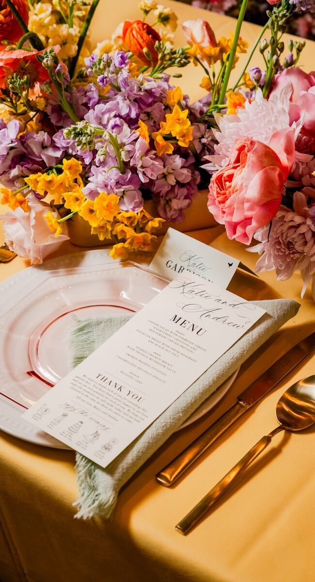 a place setting with flowers and a menu