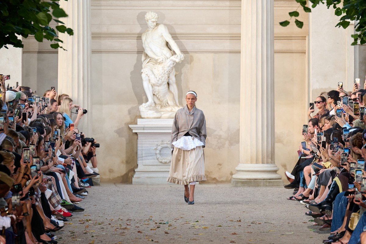 The open-air show in the King's Garden, a formal, historic Copenhagen setting, featured models alongside friends of the house and new faces, making the presentation feel like an expanded version of the brand's own community.