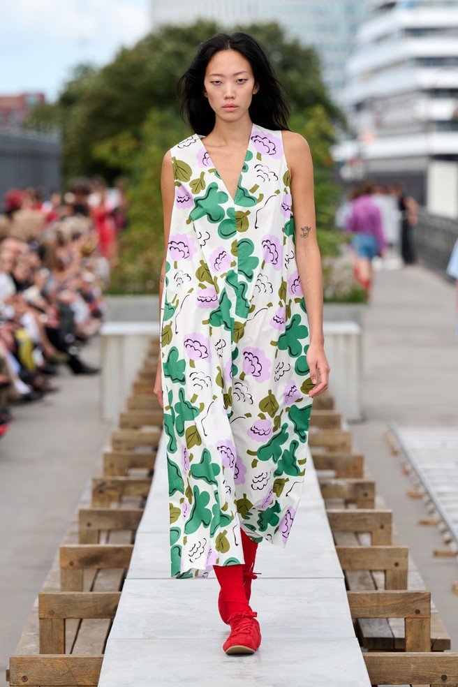 Marimekko, a Finnish design company renowned for its original prints and colors, came to Copenhagen with a different advantage: owning visual assets strong enough to do the introduction before the press release begins. They transformed a concrete communal dining table on the rooftop of the historic Langelinieskuret into a runway, while the SS27 theme, The art, the artist, and the landscape, was delivered through recognizable colors, abstracted florals and stripes, and forms inspired by desert terrain.