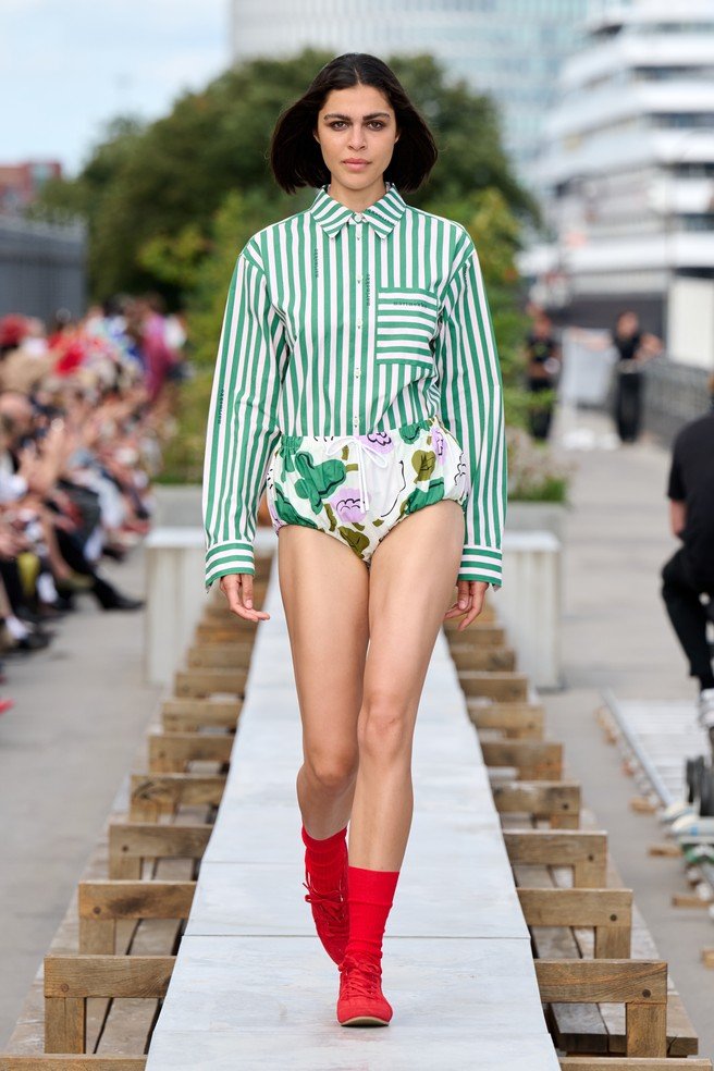 Marimekko, a Finnish design company renowned for its original prints and colors, came to Copenhagen with a different advantage: owning visual assets strong enough to do the introduction before the press release begins. They transformed a concrete communal dining table on the rooftop of the historic Langelinieskuret into a runway, while the SS27 theme, The art, the artist, and the landscape, was delivered through recognizable colors, abstracted florals and stripes, and forms inspired by desert terrain.
