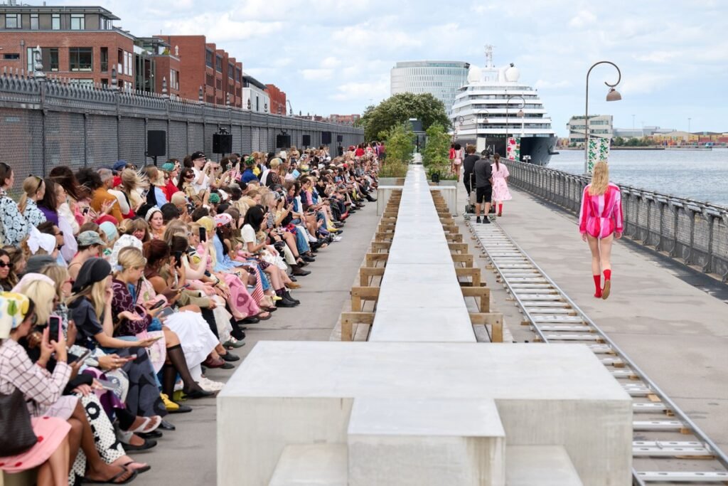 Marimekko, a Finnish design company renowned for its original prints and colors, came to Copenhagen with a different advantage: owning visual assets strong enough to do the introduction before the press release begins. They transformed a concrete communal dining table on the rooftop of the historic Langelinieskuret into a runway, while the SS27 theme, The art, the artist, and the landscape, was delivered through recognizable colors, abstracted florals and stripes, and forms inspired by desert terrain.